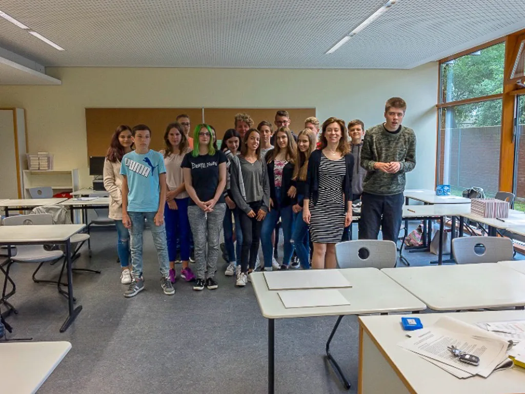 Klassengruppe steht für ein Foto im Klassenraum.